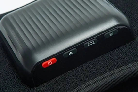 Hot Wave Massage Belt Close-up of a black control unit with a red power button and function icons on a belt.