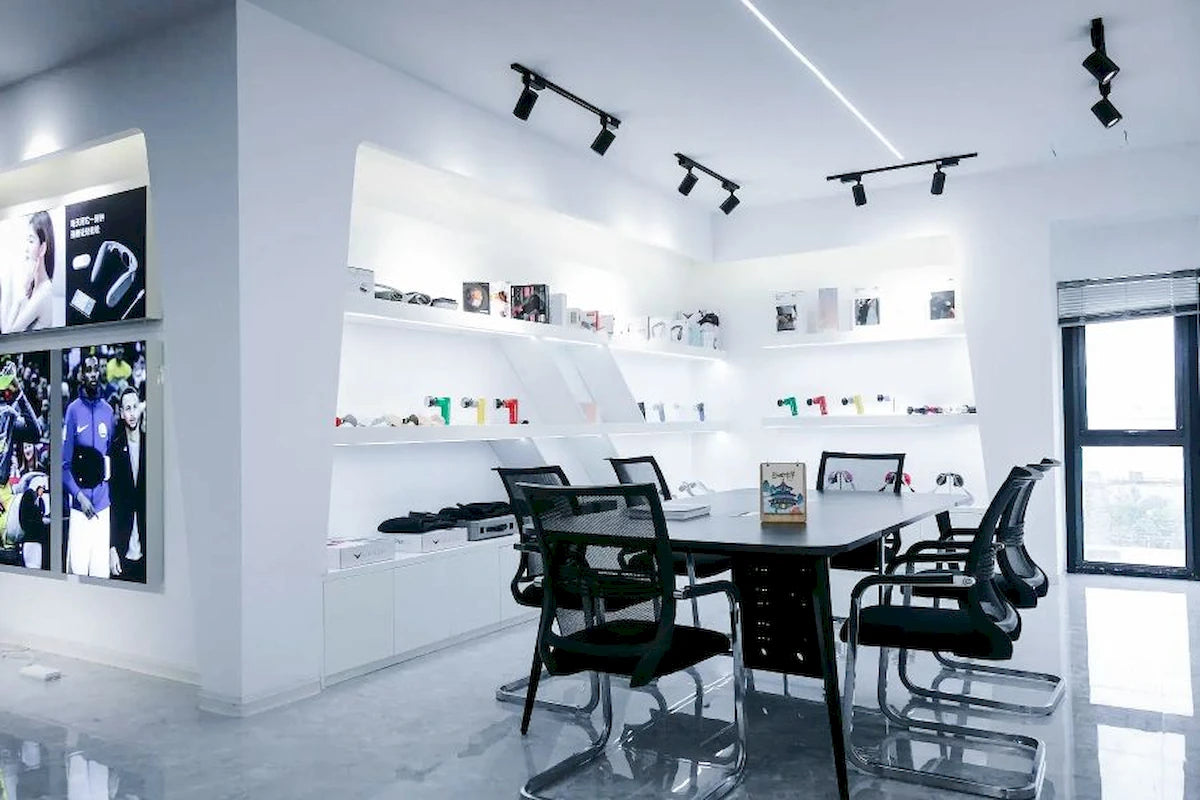 Our_Story_-_corporate_product_showroom_and_meeting_room_with_executive_conference_table_and_massager_display_shelves-Pages-Ecozy