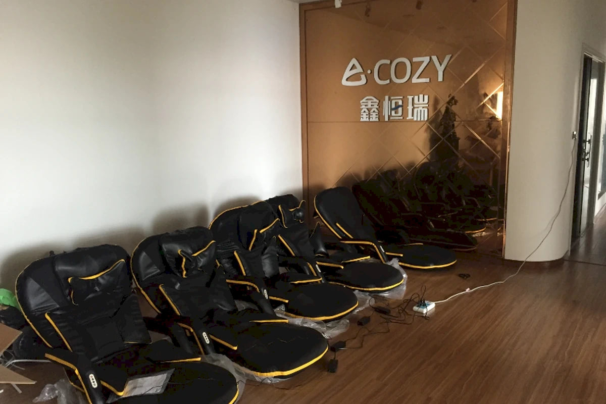 Our_Story_-_vintage_office_lobby_reception_entrance_with_golden_logo_wall_displaying_early_massage_chair_models-Pages-Ecozy