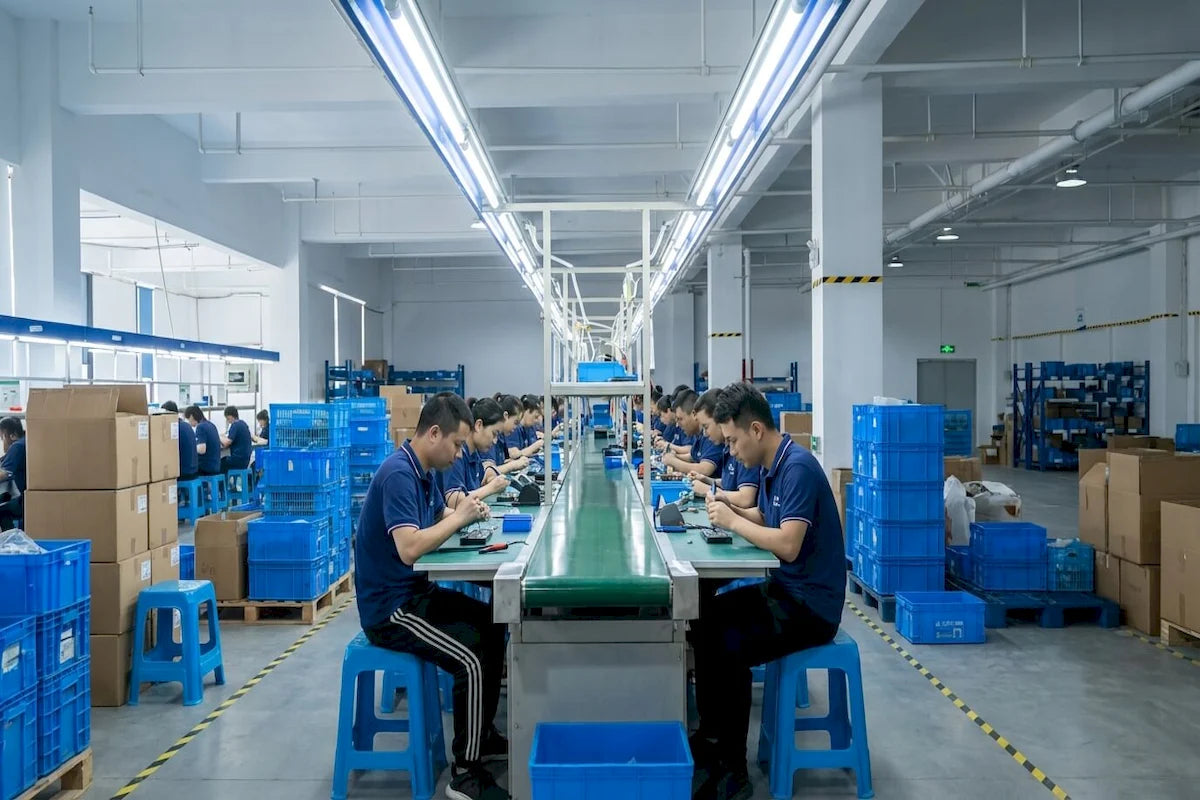 Our_Story_-_wide_view_of_workers_assembling_electronic_massagers_on_a_modern_clean_factory_production_line-Pages-Ecozy