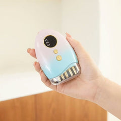EMS Beauty Massager A person's hand holding the pink and blue gradient EMS beauty massager against a blurred background.